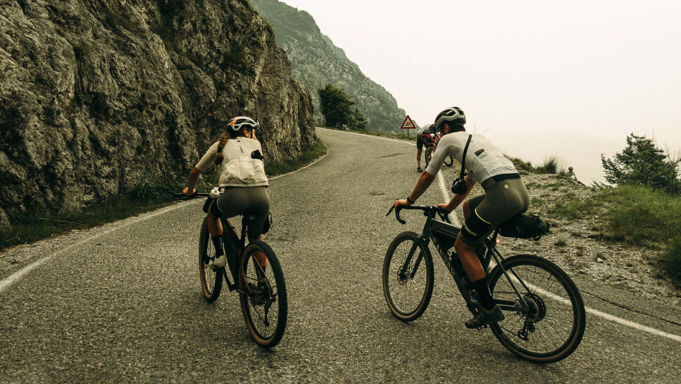 Lighting options for bikepacking bikes&mdash;riders tackle winding mountain roads with lights and gear ready for long-distance travel.